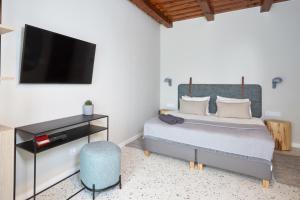 a bedroom with a bed and a flat screen tv at Veranda in Villány