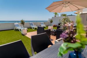 a patio with a table and chairs and an umbrella at MAKENZY Seaview PENTHOUSE in Larnaca