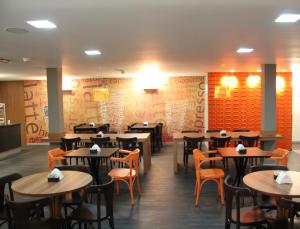 a dining room with wooden tables and chairs at Vista Inn Express Contagem in Contagem +28 photos