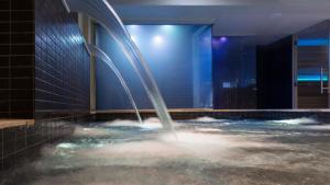 a water fountain in a pool in a building at Perla Verde Hotel in Milano Marittima