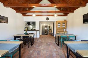 a dining room with tables and chairs and wooden ceilings at Veranda in Villány