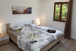 Un dormitorio con una cama con un edredón blanco y negro. en Residence Villa Fiore Portorož, en Portorož