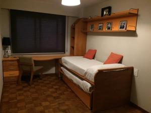 1 dormitorio con escritorio, 1 cama, escritorio y ventana en Arenal Silgar, en Sanxenxo