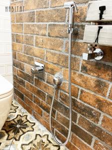 una ducha con una manguera pegada a una pared de ladrillo en habitat The River Apartment en Ruse