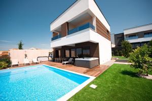 a villa with a swimming pool in front of a house at Villa Estate in Novalja