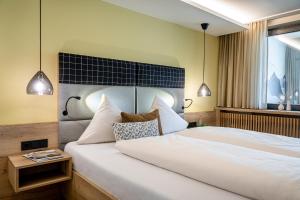 um quarto com uma grande cama branca e uma janela em Hotel Klingler em Maurach