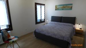 Un dormitorio con una cama y una silla dentro. en CASA MODERNA A DUE PASSI DA RIALTO, en Venecia