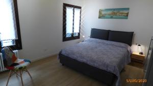 Un dormitorio con una cama y una silla dentro. en CASA MODERNA A DUE PASSI DA RIALTO, en Venecia