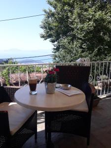 a table and chairs on a patio with a view of the ocean at Mansion Theodora in Makrinitsa