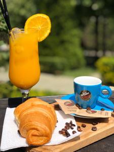 una mesa con una bebida y un cruasán y una taza de café en Hotel Ambasador Garden, en Lezhë