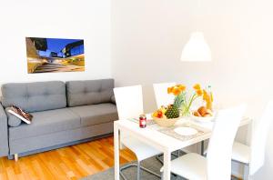 een woonkamer met een tafel en een bank bij Relax Aachener Boardinghouse Appartements Premium 1 in Aken
