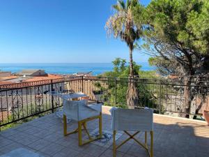 um pátio com 2 cadeiras e uma mesa na varanda em Vista Mare a 300 mt dalla spiaggia em Cariati