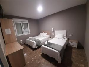 a hotel room with two beds and two windows at AYAMONTE ROOMS 43 in Ayamonte +20 photos