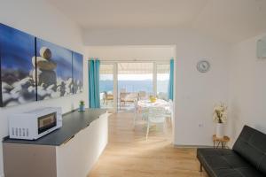 a kitchen and living room with a microwave on a counter at Exclusive Seaside Dream Apartments in Murter