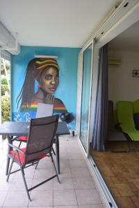 a room with a painting of a woman on the wall at Le Paradis des Doudous/Résidence Corail in Sainte-Anne