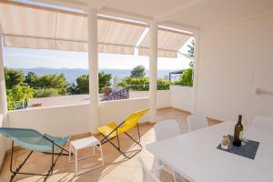 a dining room with a white table and yellow chairs at Exclusive Seaside Dream Apartments in Murter
