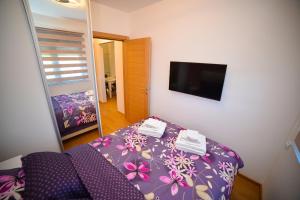 a small bedroom with a bed and a mirror at Apartment Center Valley in Vila Pekovic Green in Zlatibor