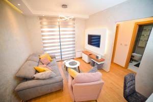 a living room with a couch and two chairs at Apartment Center Valley in Vila Pekovic Green in Zlatibor