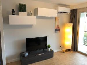 un salon avec une télévision à écran plat sur un mur dans l'établissement BERMUDAS-TURIS Apartamentos, à Benidorm