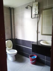 La salle de bains est pourvue de toilettes, d'un lavabo et d'un miroir. dans l'établissement MIRAMAR HOTEL, à Sibu