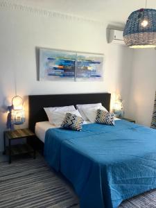 een slaapkamer met een blauw bed met 2 kussens erop bij Chambre d Hôte exclusif Naturiste et Nudiste CASA AMSYL adultes only in Paderne