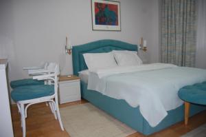 a bedroom with a blue bed and two chairs at RI-VAL in Valandovo