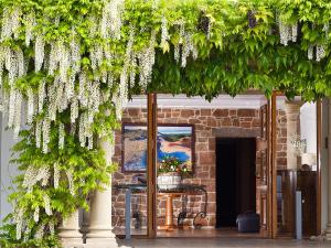 un montón de flores blancas colgando de un edificio en The Atlantic Hotel en St Brelade