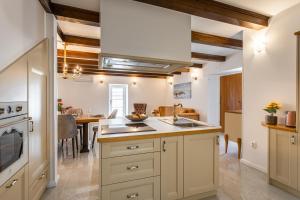 een keuken met witte kasten, een wastafel en een tafel bij Villa Frana in Krk