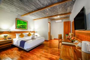 a bedroom with a bed and a flat screen tv at Munduk Heaven Luxury Villas in Munduk +45 photos