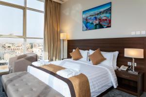 Seiba Hotel Apartments-Riyadh في الرياض: غرفة فندقية بسرير كبير ونافذة