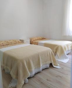 two beds sitting next to each other in a room at Living Pontevedra in Pontevedra