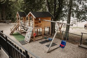 a childrens playground with a wooden play house at Słoneczna in Sieraków