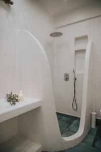 a bathroom with a shower with a round mirror at Manthos Place in Mylopotas