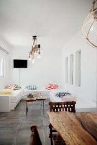 a white living room with a couch and a table at Manthos Place in Mylopotas