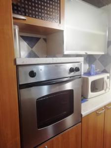 a kitchen with a stainless steel oven and a microwave at Casa San Salvatore in Càbras