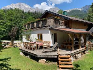 a house with a wooden deck with a table and chairs at AlpinCreek in Leogang