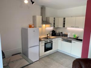 cocina con armarios blancos y nevera en Ferienwohnung zur Dexter-Zucht Coswig (Anhalt), en Coswig