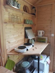 uma pequena cozinha com um fogão numa cabina de madeira em Quinta Portugo em Cernache do Bonjardim