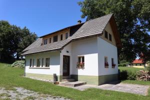 una pequeña casa blanca con techo negro en Ferienhaus Dobernigg, en Sankt Jakob im Rosental