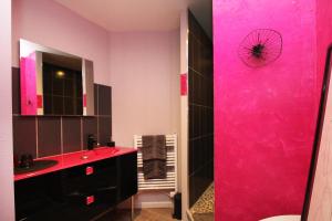 a pink bathroom with a sink and a mirror at Au Domaine de PY in Le Valtin