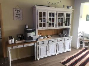 a kitchen with a large white cabinet with a coffee maker at Pensiunea Talhaus in Vişeu de Sus