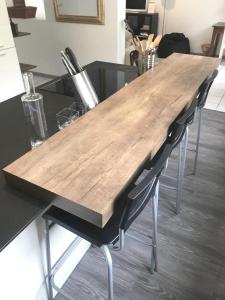 a wooden table with chairs at a kitchen counter at Chalet Étoile des neiges in Barèges