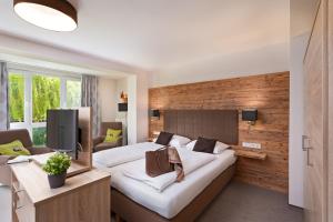ein Hotelzimmer mit einem großen Bett und einem TV in der Unterkunft Richstein's Posthotel in Bad Füssing