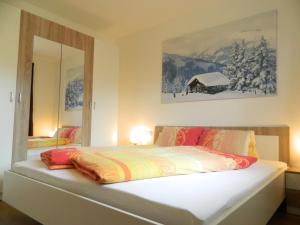 a bedroom with a large white bed with a mirror at Haus 4 Holidays in Bramberg am Wildkogel