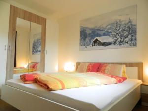Schlafzimmer mit einem großen weißen Bett und einem Spiegel in der Unterkunft Haus 4 Holidays in Bramberg am Wildkogel