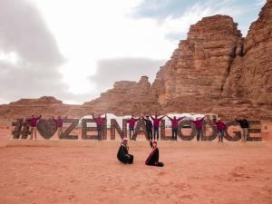 two people sitting on the ground in the desert at Zeina Desert Lodge in Wadi Rum