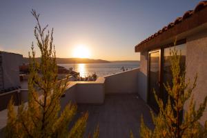 einen Balkon mit Blick auf das Meer bei Sonnenuntergang in der Unterkunft Hotel Kale 17 in Canakkale