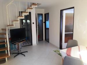 sala de estar con TV de pantalla plana y escaleras en Retrovilla, en Balatonkenese