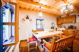 a dining room with a wooden table and chairs at Casa lu' Ion in Vişeu de Sus +44 photos
