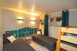 ル・ヴァルタンにあるAu Domaine de PYの小さな客室で、ベッド2台、二段ベッド1組が備わります。